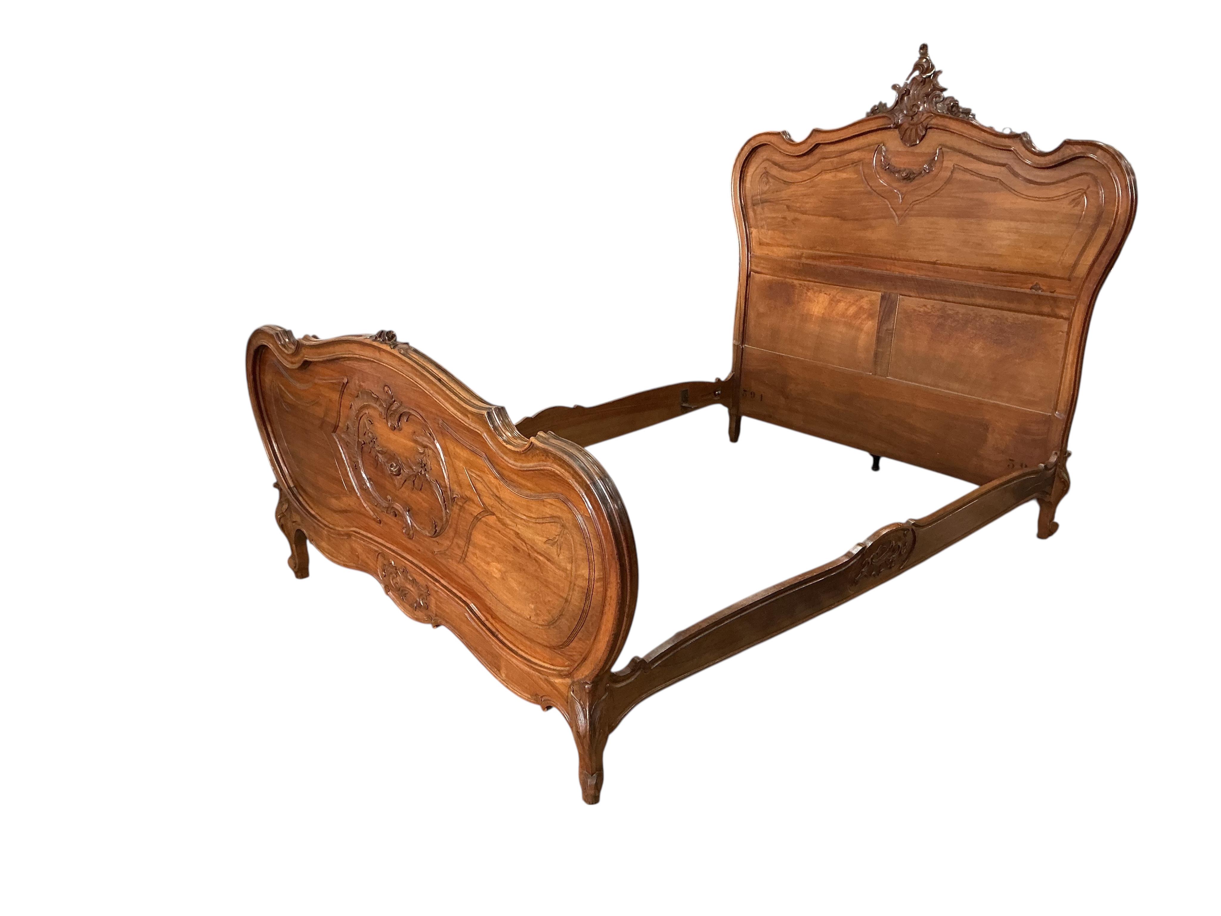An early 20th century Louis XV style carved walnut bedframe, width 143cm, length 204cm, height 156cm